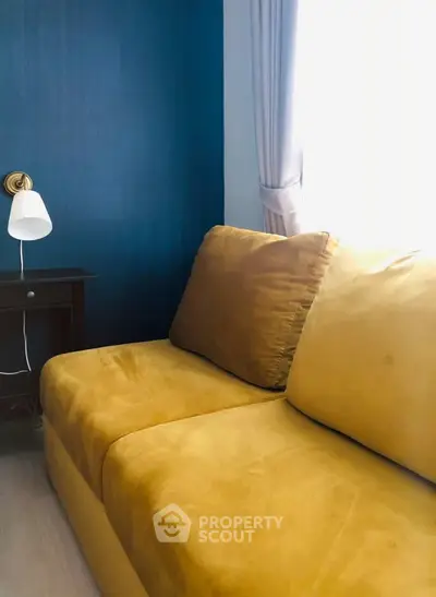 Stylish living room with vibrant yellow sofa and elegant blue accent wall
