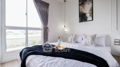 Bright and cozy bedroom with large window and elegant decor, perfect for relaxation.