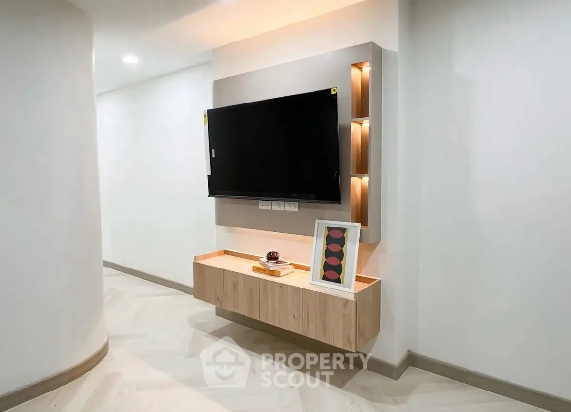 Modern hallway with mounted TV and stylish lighting, showcasing sleek interior design.