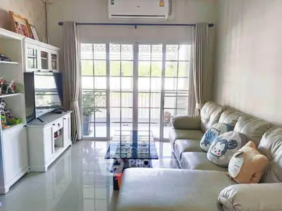 Stylish living room with modern furniture and large windows opening to a balcony.