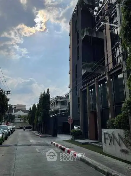 Modern urban building exterior with street view and lush greenery