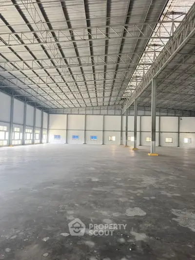 Spacious industrial warehouse with high ceilings and ample natural light.