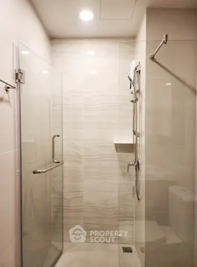 Modern bathroom with glass shower enclosure and sleek fixtures.