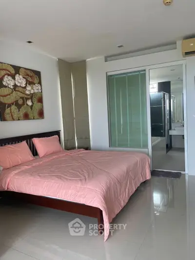 Modern bedroom with pink bedding and ensuite bathroom in luxury apartment
