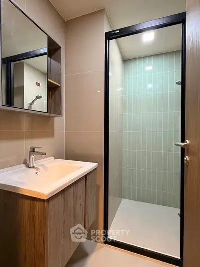 Modern bathroom with sleek shower and stylish vanity in contemporary apartment.