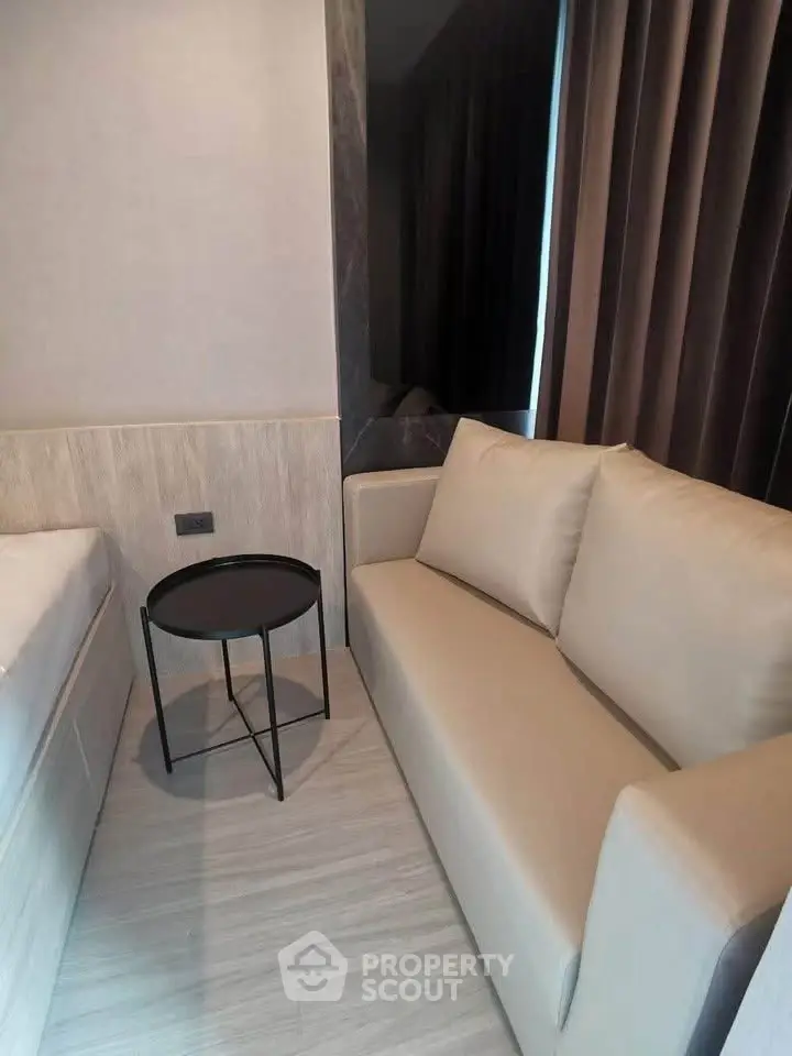 Modern compact living room with cozy sofa and sleek side table in stylish apartment.