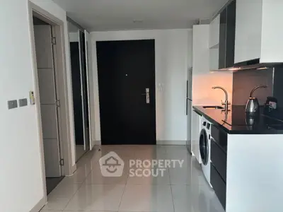 Modern kitchen with sleek black countertops and built-in appliances in a stylish apartment.