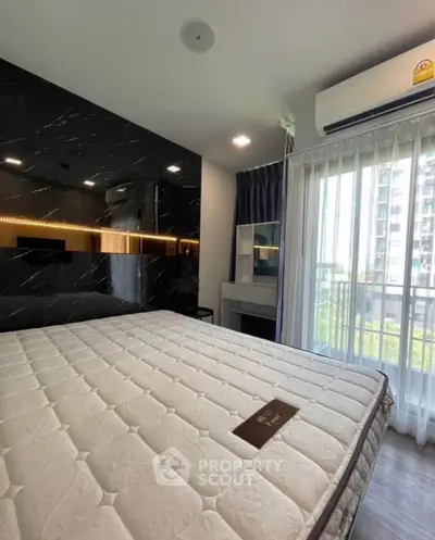 Modern bedroom with large window and stylish decor in a high-rise apartment.