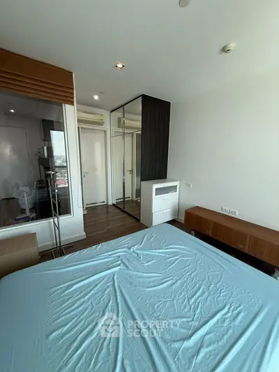 Modern bedroom with sleek design and ample natural light, featuring a large bed and stylish furniture.