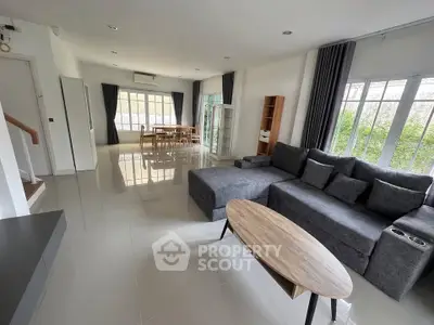 Spacious modern living room with sleek furniture and large windows for natural light.
