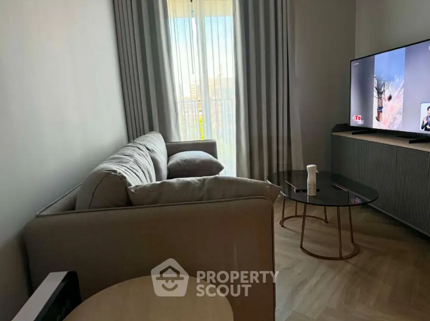 Cozy living room with modern sofa and TV, perfect for relaxation.