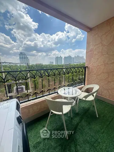 Charming balcony with city view, featuring cozy seating and lush greenery, perfect for relaxation.
