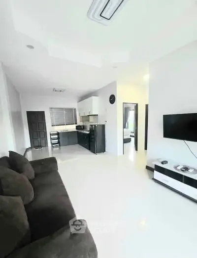 Modern open-plan living room with sleek kitchen and cozy seating area, perfect for contemporary living.