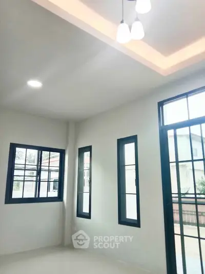 Bright and airy living room with large windows and modern lighting in a contemporary home.