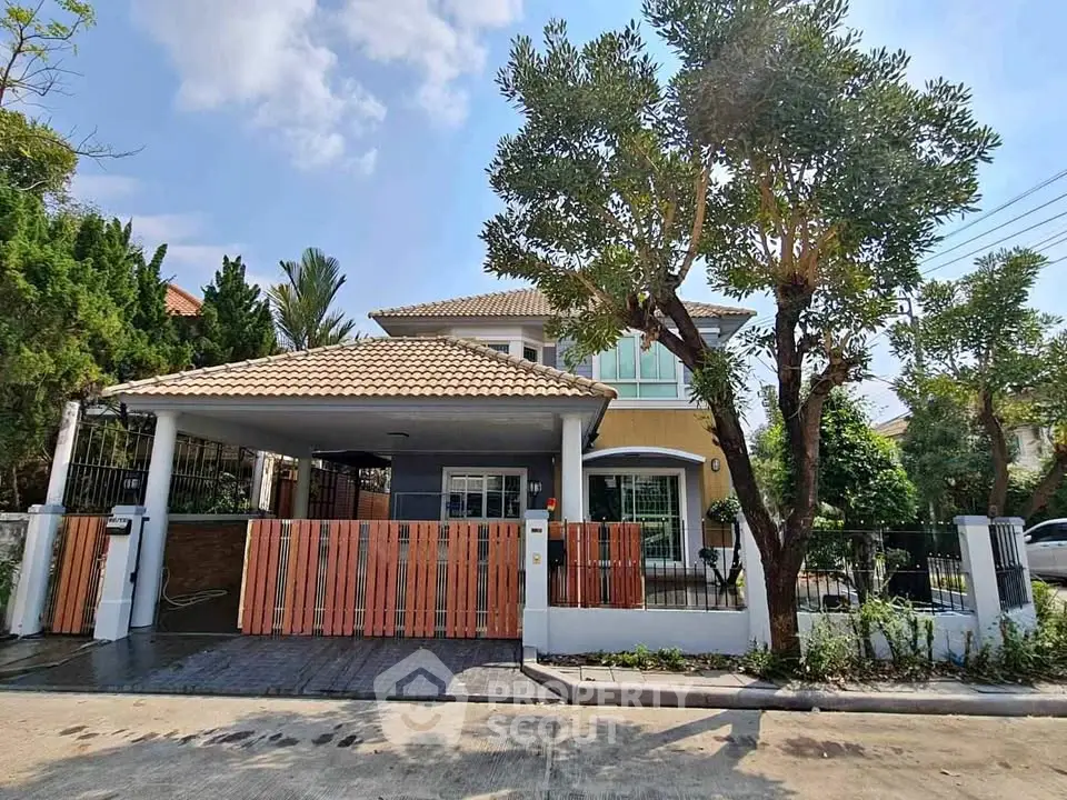 Charming two-story house with spacious driveway and lush greenery in a serene neighborhood.