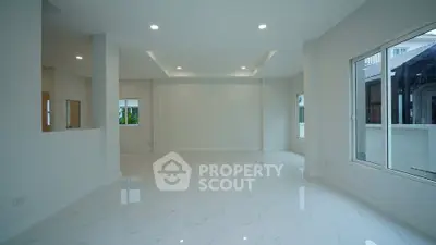 Spacious modern living room with large windows and elegant flooring