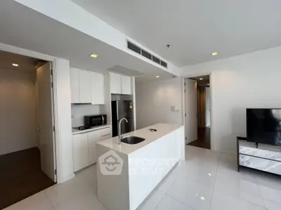 Modern kitchen with sleek white cabinetry and island in open layout apartment