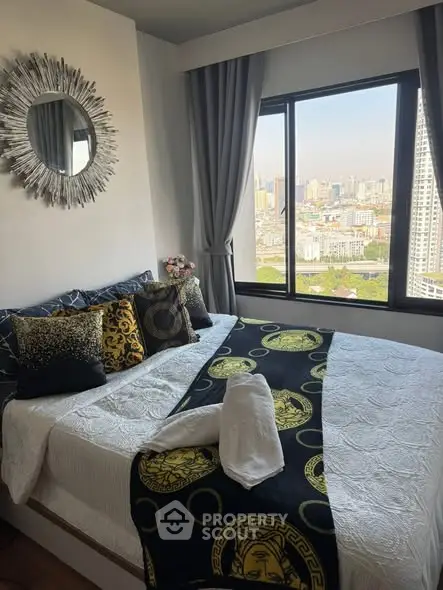 Stylish bedroom with city view, featuring elegant decor and large window for natural light.