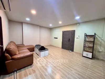 Spacious living room with modern brown leather sofa and sleek tile flooring