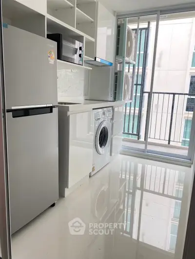 Modern kitchen with sleek appliances and balcony access