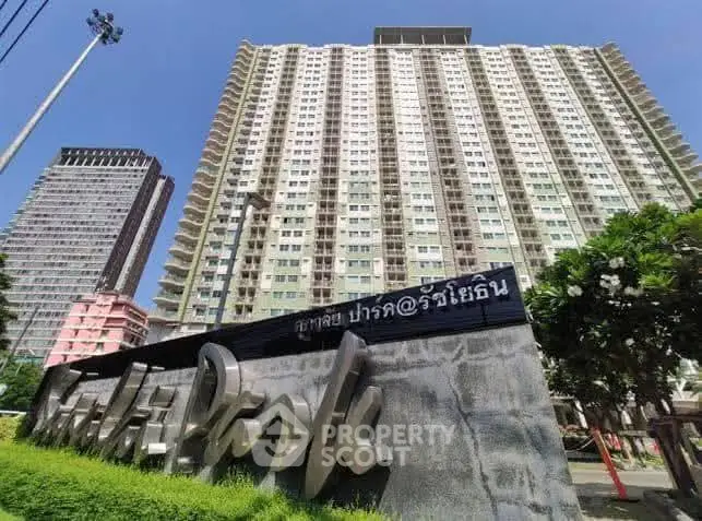 High-rise condominium building with modern architecture and lush greenery.