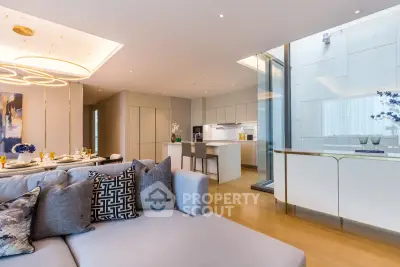 Luxurious open-plan living room and kitchen with modern decor and elegant lighting.