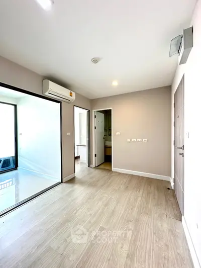 Bright and modern living space with wooden flooring and air conditioning