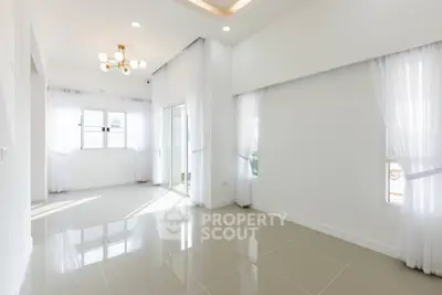Spacious and bright living room with modern lighting and large windows.
