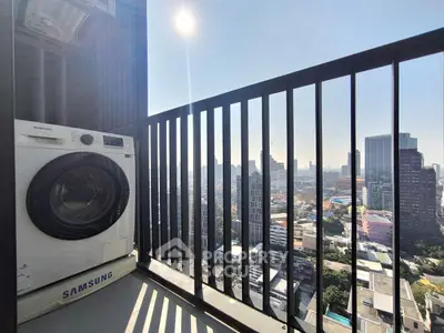 Stunning city view from high-rise balcony with washing machine setup.