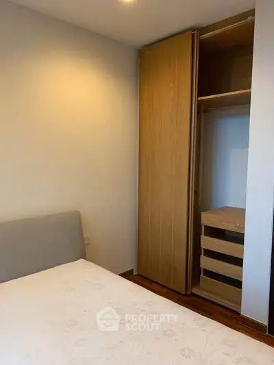Cozy bedroom with built-in wooden wardrobe and comfortable bed