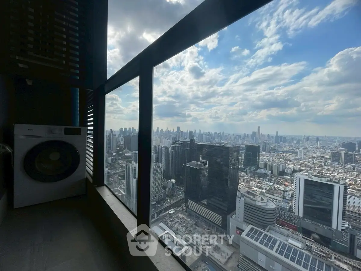 Stunning high-rise city view from a modern balcony with washing machine.