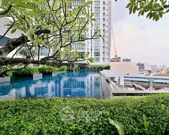 Luxurious rooftop pool with stunning city views and lush greenery in a modern high-rise building.