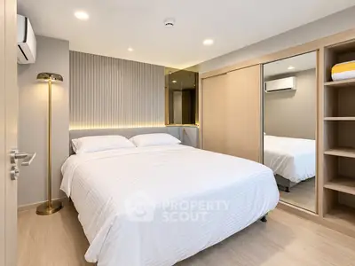 Modern bedroom with elegant lighting and mirrored wardrobe in a stylish apartment.