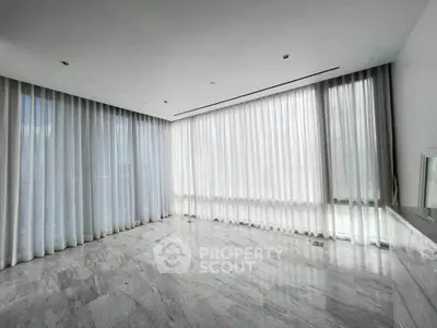 Spacious corner unit with floor-to-ceiling windows and elegant marble flooring.