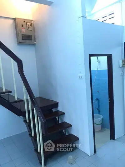Compact interior with staircase and small bathroom, ideal for efficient space utilization.