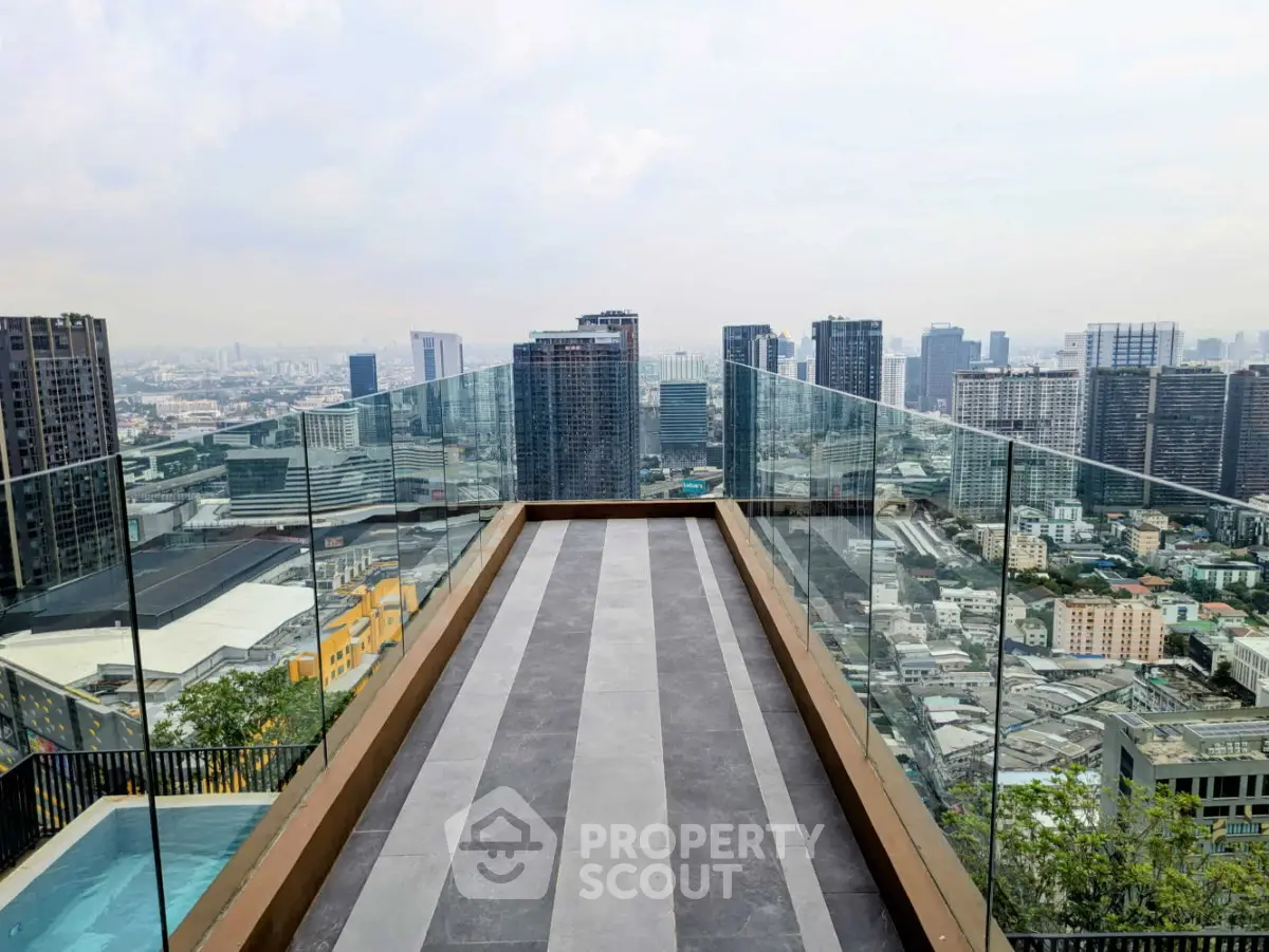Stunning rooftop view with glass railing overlooking city skyline, perfect for urban living enthusiasts.