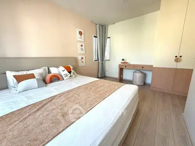 Modern bedroom with stylish decor and natural light, featuring a cozy bed and elegant wooden furniture.