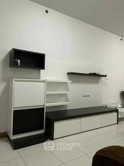 Modern minimalist living room with sleek black and white shelving unit.