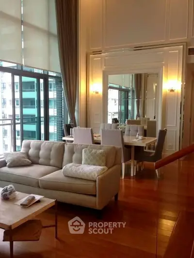 Luxurious living room with elegant decor and large windows offering stunning city views.