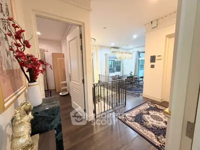 Elegant interior hallway leading to a spacious living room with modern decor and natural light.