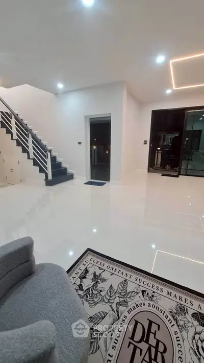 Modern interior with sleek staircase and glossy white flooring, perfect for contemporary living.