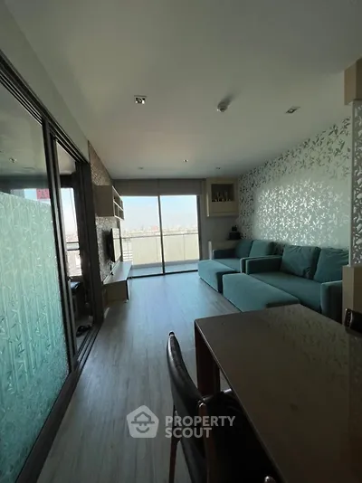 Modern living room with large windows and stylish decor, offering a bright and inviting atmosphere.