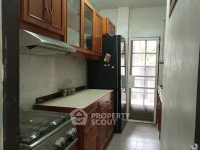 Charming kitchen with wooden cabinets and modern appliances in cozy apartment.
