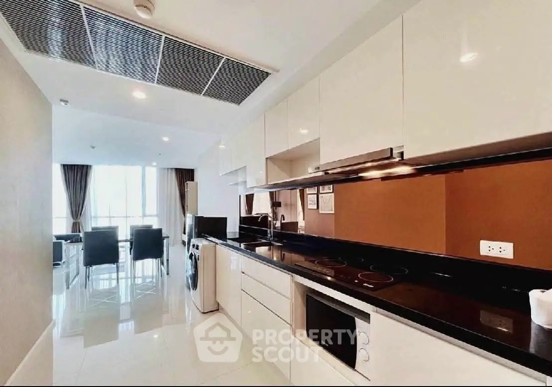Modern kitchen with sleek cabinetry and dining area in luxury apartment