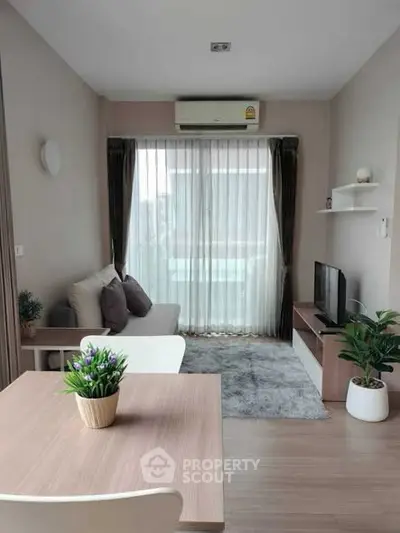 Modern living room with natural light, cozy seating, and stylish decor in a contemporary apartment.