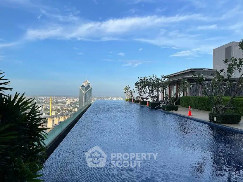 Stunning rooftop infinity pool with panoramic city views and lush greenery.
