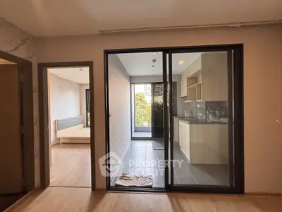 Modern apartment interior with open kitchen and bedroom view