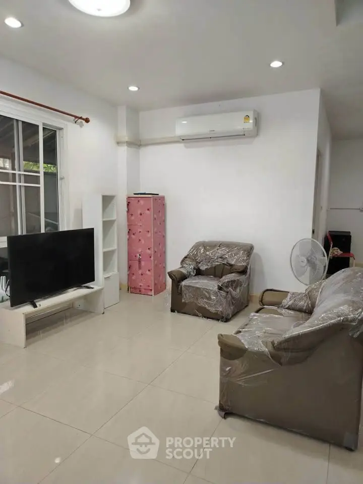 Spacious living room with modern furniture and air conditioning, perfect for relaxation.