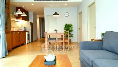 Spacious modern living room with open kitchen and elegant wooden furniture.