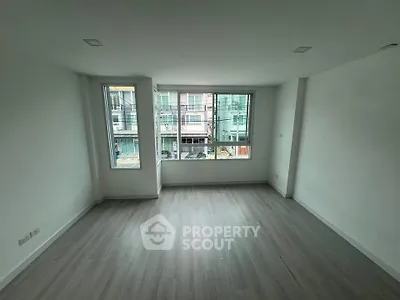 Spacious empty room with large windows and modern flooring, ideal for customization.